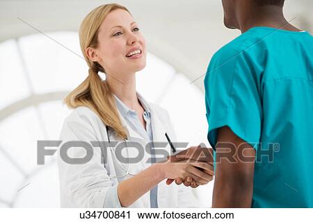 Two doctors shaking hands View Large Photo Image Stock Image - Two doctors shaking hands. Fotosearch