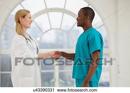 Two doctors shaking hands View Large Photo Image Stock Image - Two doctors shaking hands. Fotosearch
