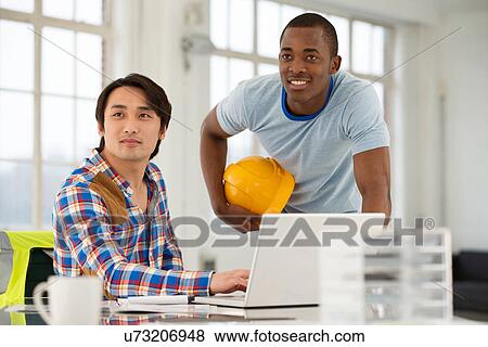 Two male engineers using laptop View Large Photo Image Stock Photo - Two male engineers using laptop. Fotosearch