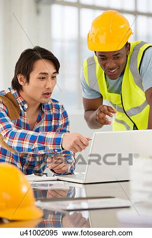 Two male engineers using laptop View Large Photo Image Stock Photography - Two male engineers using laptop. Fotosearch
