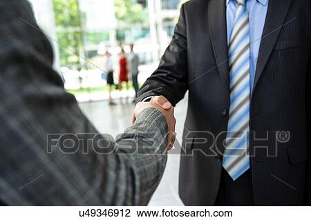 Stock Image - Two men shaking hands. Fotosearch