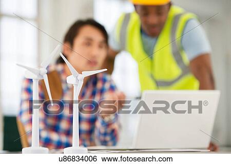 Stock Photograph - Two men with models of wind turbines in foreground. Fotosearch