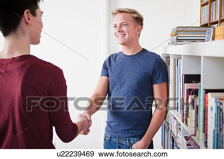 Two young men shaking hands View Large Photo Image Stock Photo - Two young men shaking hands. Fotosearch