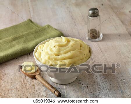 Stock Photography - Ultimate mashed potato with black pepper in white faceted bowl with wooden spoon. Fotosearch