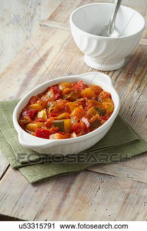 Vegetable ratatouille. Courgettes, tomatoes and red and yellow peppers in white dish on a green cloth View Large Photo Image Stock Image - Vegetable ratatouille. Courgettes, tomatoes and red and yellow peppers in white dish on a green cloth. Fotosearch