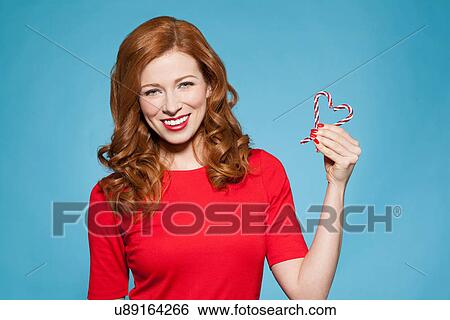 Stock Photograph - Woman holding heart shaped candy. Fotosearch
