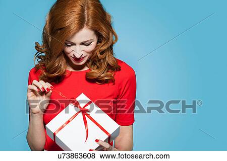 Stock Photo - Woman holding white gift box with red bow. Fotosearch