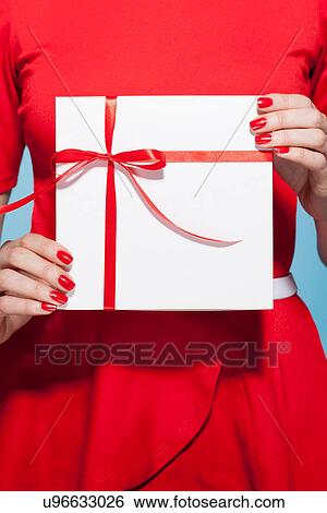 Woman holding white gift box with red bow, mid section View Large Photo Image Stock Photograph - Woman holding white gift box with red bow, mid section. Fotosearch