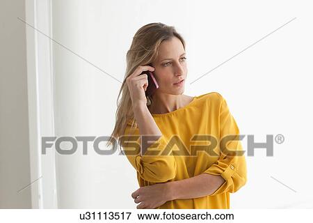 Woman in yellow top on cell phone View Large Photo Image Stock Photo - Woman in yellow top on cell phone. Fotosearch
