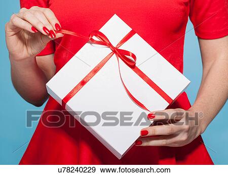 Woman opening white gift box with red bow, mid section View Large Photo Image Stock Photo - Woman opening white gift box with red bow, mid section. Fotosearch