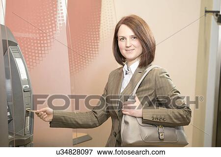 Stock Photo - Woman using cashpoint. Fotosearch