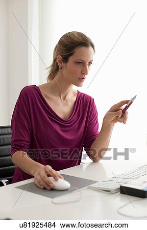 Woman using computer mouse, holding pen View Large Photo Image Picture - Woman using computer mouse, holding pen. Fotosearch
