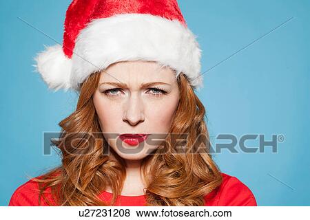 Woman wearing santa hat, frowning View Large Photo Image Stock Photo - Woman wearing santa hat, frowning. Fotosearch