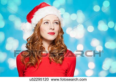 Stock Image - Woman wearing santa hat. Fotosearch