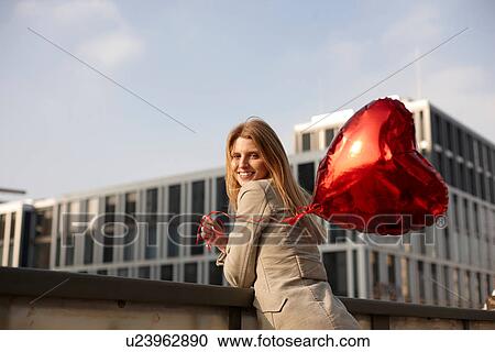 Woman with red heart-shaped balloon View Large Photo Image Stock Image - Woman with red heart-shaped balloon. Fotosearch