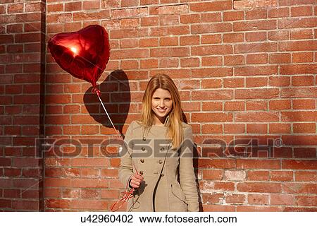 Woman with red heart-shaped balloon View Large Photo Image Stock Image - Woman with red heart-shaped balloon. Fotosearch