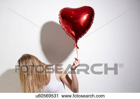 Woman with red heart-shaped balloon View Large Photo Image Stock Image - Woman with red heart-shaped balloon. Fotosearch