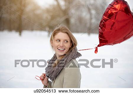 Woman with red heart-shaped balloon View Large Photo Image Stock Image - Woman with red heart-shaped balloon. Fotosearch