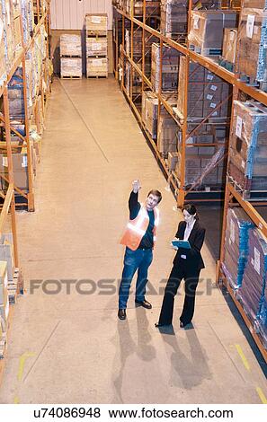 Stock Photo - Worker and supervisor in warehouse. Fotosearch