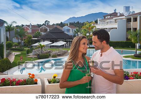 Young couple at holiday resort with champagne View Large Photo Image Stock Image - Young couple at holiday resort with champagne. Fotosearch