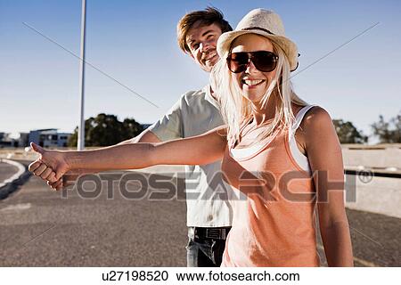 Young couple hitch hiking View Large Photo Image Stock Image - Young couple hitch hiking. Fotosearch