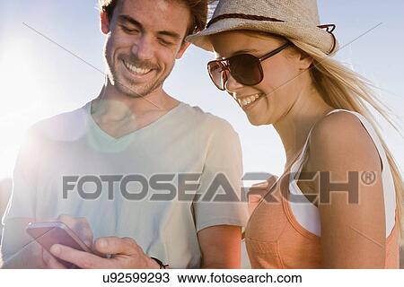 Stock Image - Young couple looking at smartphone. Fotosearch