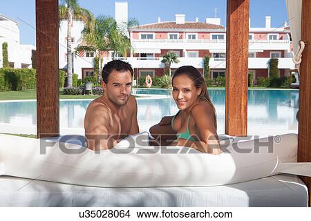 Young couple relaxing on sunlounger at holiday resort View Large Photo Image Picture - Young couple relaxing on sunlounger at holiday resort. Fotosearch