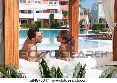 Young couple relaxing on sunlounger at holiday resort View Large Photo Image Stock Photo - Young couple relaxing on sunlounger at holiday resort. Fotosearch
