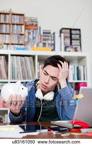 Young man holding piggy bank View Large Photo Image Stock Image - Young man holding piggy bank. Fotosearch