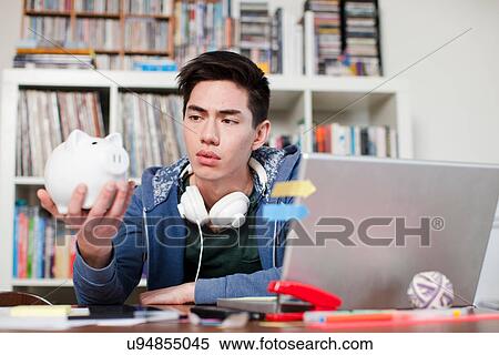 Young man holding piggy bank View Large Photo Image Stock Photography - Young man holding piggy bank. Fotosearch