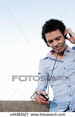 Stock Photo - Young man listening to music. Fotosearch
