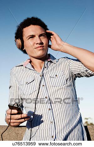 Young man listening to music View Large Photo Image Stock Photo - Young man listening to music. Fotosearch