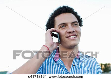Young man on cellphone View Large Photo Image Picture - Young man on cellphone. Fotosearch