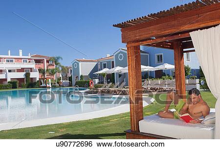 Young man relaxing at holiday resort View Large Photo Image Stock Photograph - Young man relaxing at holiday resort. Fotosearch