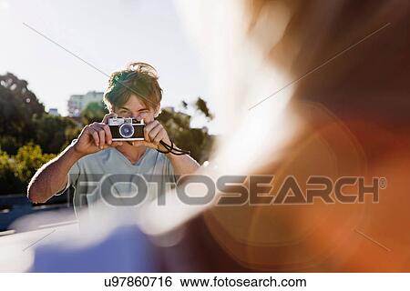 Stock Photograph - Young man taking pictures. Fotosearch
