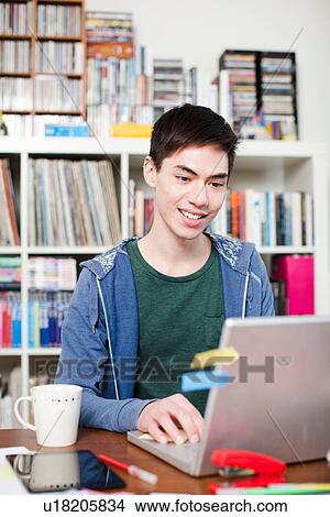 Young man working on laptop View Large Photo Image Picture - Young man working on laptop. Fotosearch
