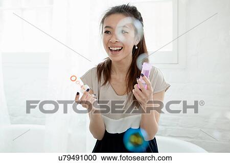 Young woman blowing bubbles with bubble wand View Large Photo Image Stock Image - Young woman blowing bubbles with bubble wand. Fotosearch