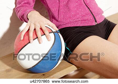 Stock Photography - Young woman holding basketball. Fotosearch