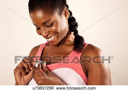 Stock Photo - Young woman holding stopwatch. Fotosearch