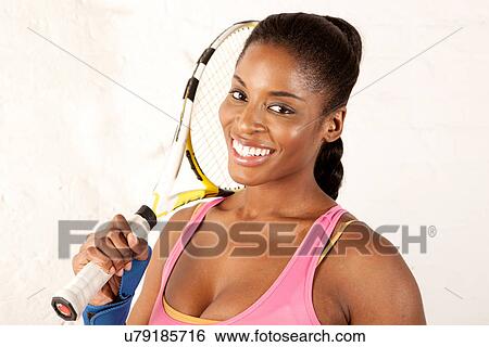 Young woman holding tennis racket View Large Photo Image Stock Photograph - Young woman holding tennis racket. Fotosearch