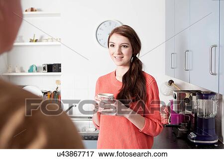 Young woman in kitchen with coffee cup View Large Photo Image Stock Photo - Young woman in kitchen with coffee cup. Fotosearch