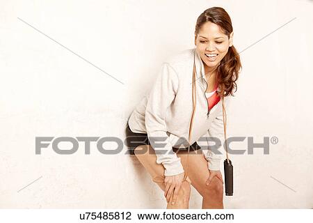 Young woman leaning against wall View Large Photo Image Stock Image - Young woman leaning against wall. Fotosearch