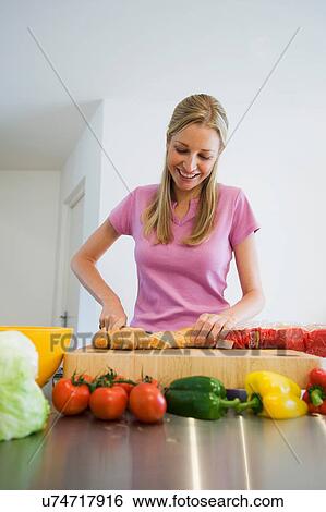 Young woman preparing food View Large Photo Image Stock Photograph - Young woman preparing food. Fotosearch