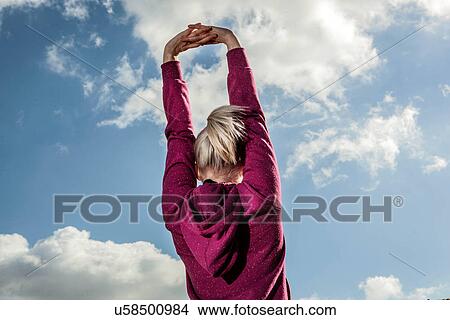 Young woman stretching with arms up View Large Photo Image Picture - Young woman stretching with arms up. Fotosearch