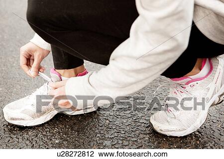 Young woman tying laces on trainers View Large Photo Image Stock Image - Young woman tying laces on trainers. Fotosearch