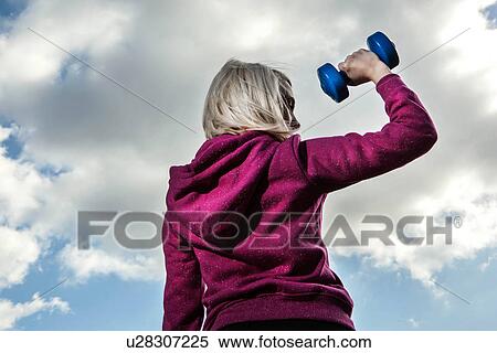 Stock Photography - Young woman using hand weights. Fotosearch