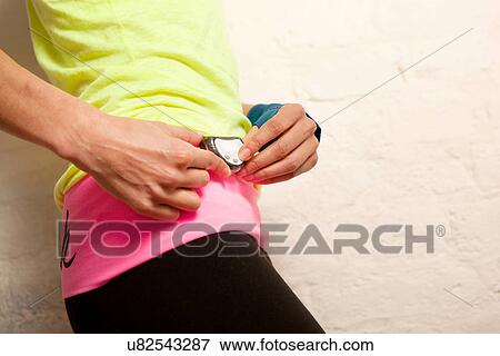 Young woman using stopwatch View Large Photo Image Stock Photo - Young woman using stopwatch. Fotosearch