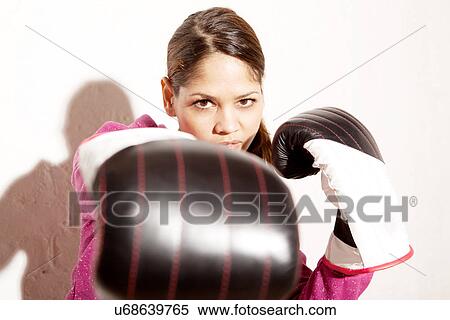 Stock Photography - Young woman wearing boxing gloves. Fotosearch
