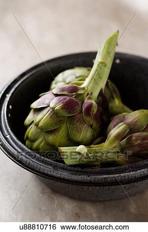 Stock Photograph - Artichokes in bowl, still life. Fotosearch