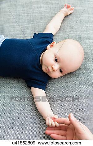 Stock Photo - Baby boy holding person's hand. Fotosearch